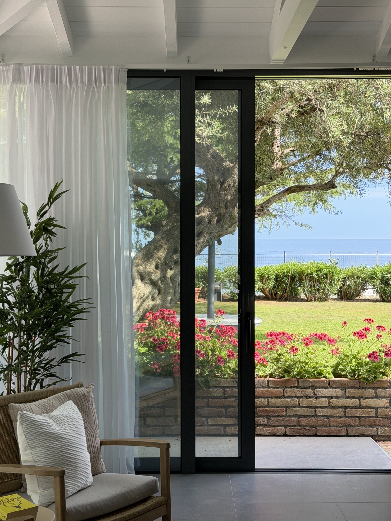 A Greek home opening onto an olive tree and sea view